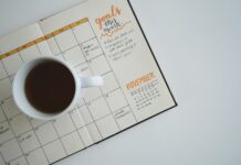 직장 내 스트레스 관리: 생산성 향상의 열쇠 white ceramic mug with coffee on top of a planner