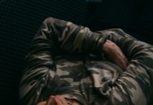 수면, 건강의 열쇠…잠을 잘 자야 몸과 마음이 산다 woman in gray and black camouflage jacket lying on black couch