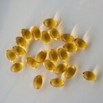 “내 몸에 맞게, 똑똑하게 챙기는 영양 & 보충제 활용법” a pile of fish oil capsules sitting on top of a table