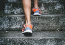 1만 보의 미신: 꼭 1만 보를 채워야 할까? 당신에게 맞는 ‘진짜’ 권장량 person wearing orange and gray Nike shoes walking on gray concrete stairs