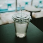 ‘마시는 물’이 건강 트렌드? 현명하게 수분 챙기는 생활 습관 clear plastic disposable cup on top of black surface