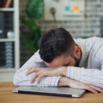 만성피로, 바꿔야 할 일상 습관… 한국식 실천 루틴으로 관리법 찾기 a man sitting at a desk with his head in his hands
