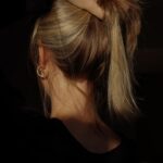 건강한 모발을 위한 최신 트렌드와 실천 루틴…집에서도 두피 관리 열풍 a woman with her hair in a bun